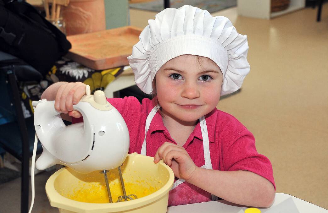 Buddying young Masterchef Isabelle makes cupcakes at Cooinda Kindergarten.