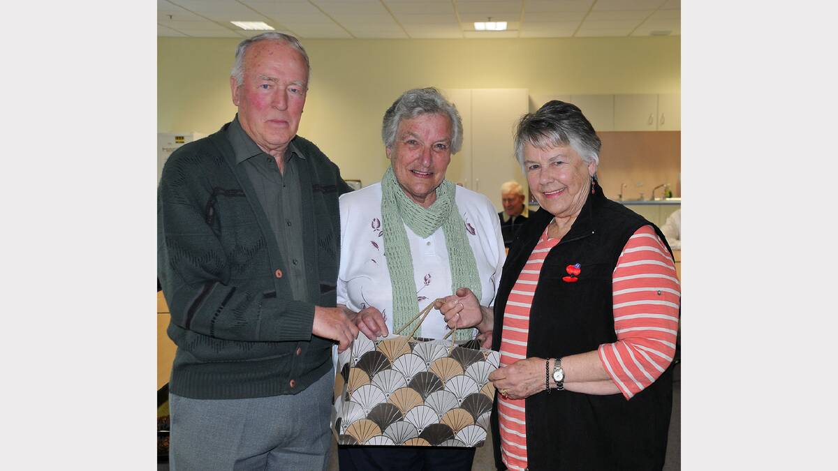Cordeila Breen (centre) receives a farewell gift from Cliff Jones and Val Toomey.
