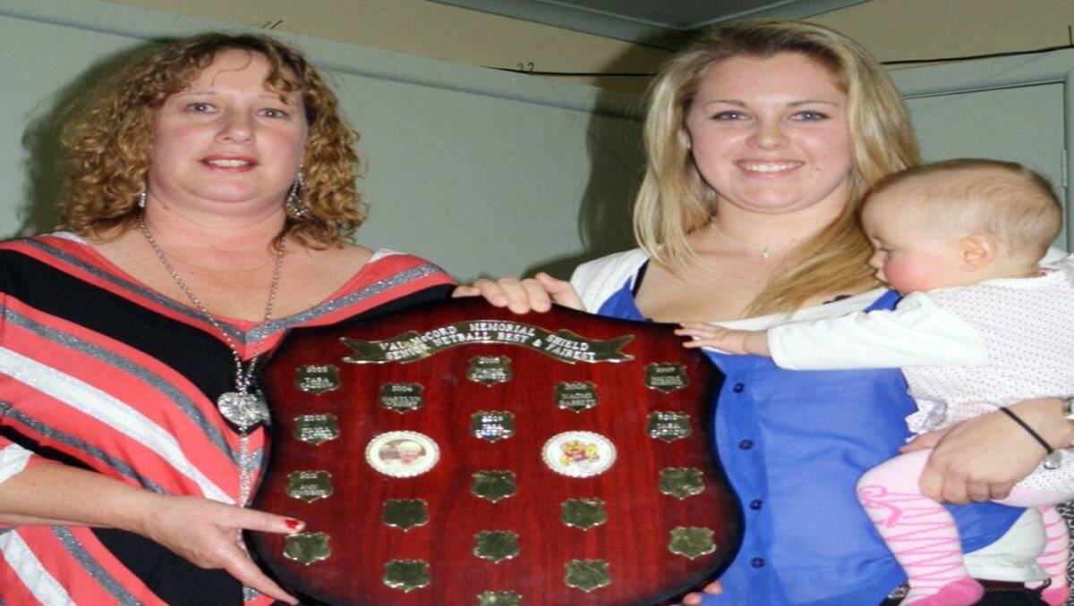 Sharlene McCord (left) presents A grade best and fairest winner Amy Kindred, with daughter Annabelle, with the Val McCord Shield.