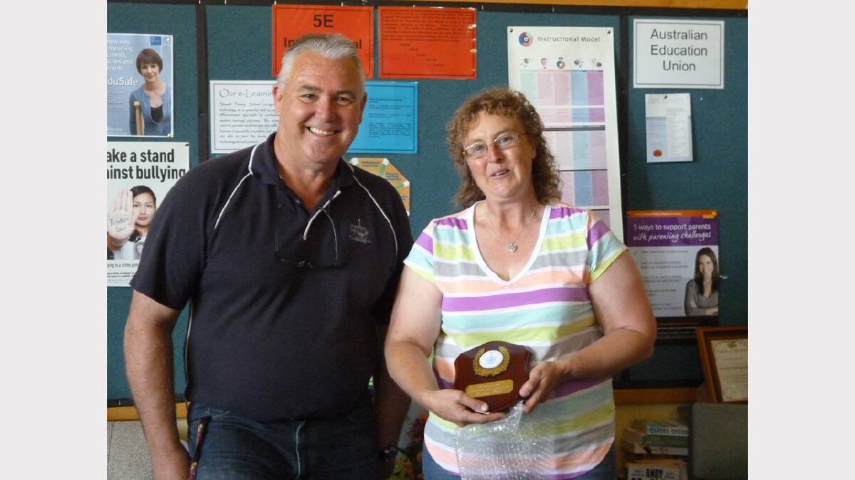 Tracey Kell receives her volunteer of the year award from acting principal John Cunningham.