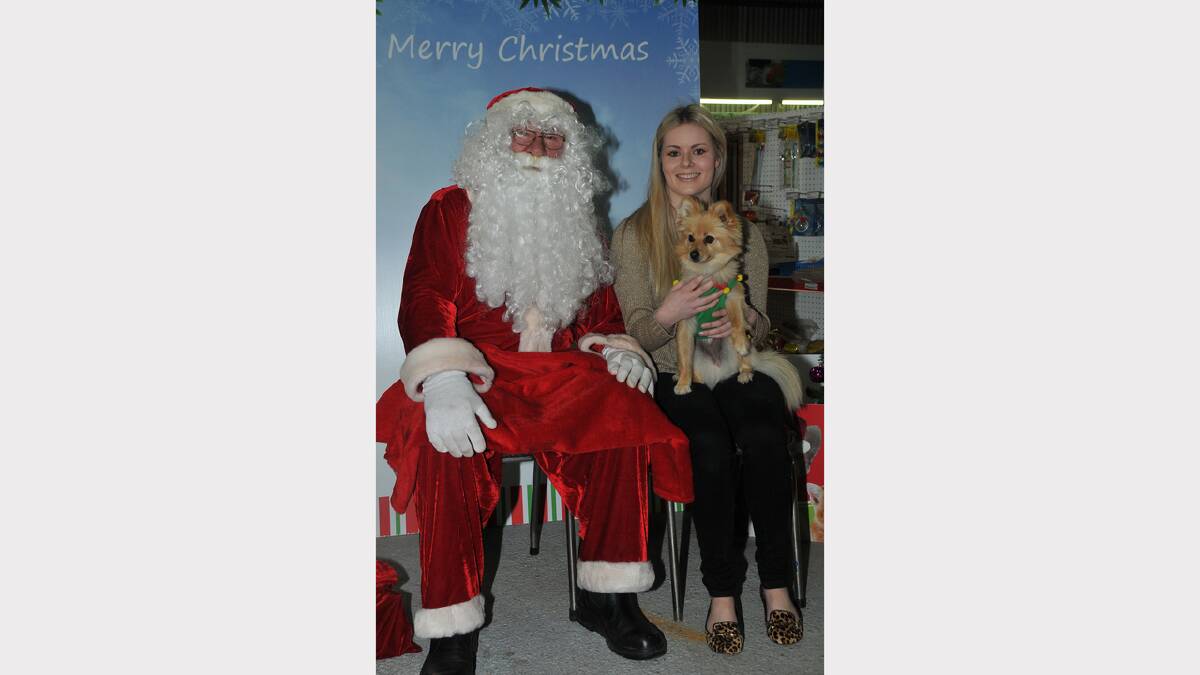 Santa poses for a photo with Amy Anderson and her pet dog Tiffany.