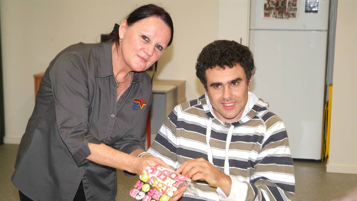 Lili Gorter is pictured assisting Xavier with his scrapbooking in the Lifeskills program area at the Powerhouse. 