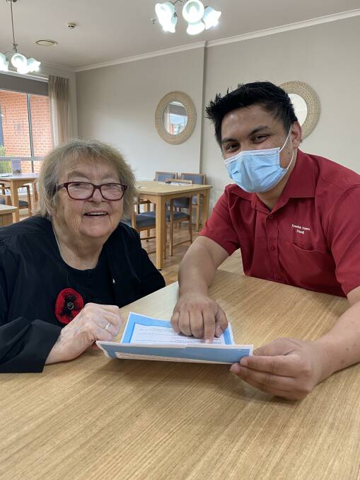 BOOSTERS: Eventide Homes resident Pat Owen discussing the COVID booster vaccination with clinical lead Bryll Villafuente. Picture: CONTRIBUTED