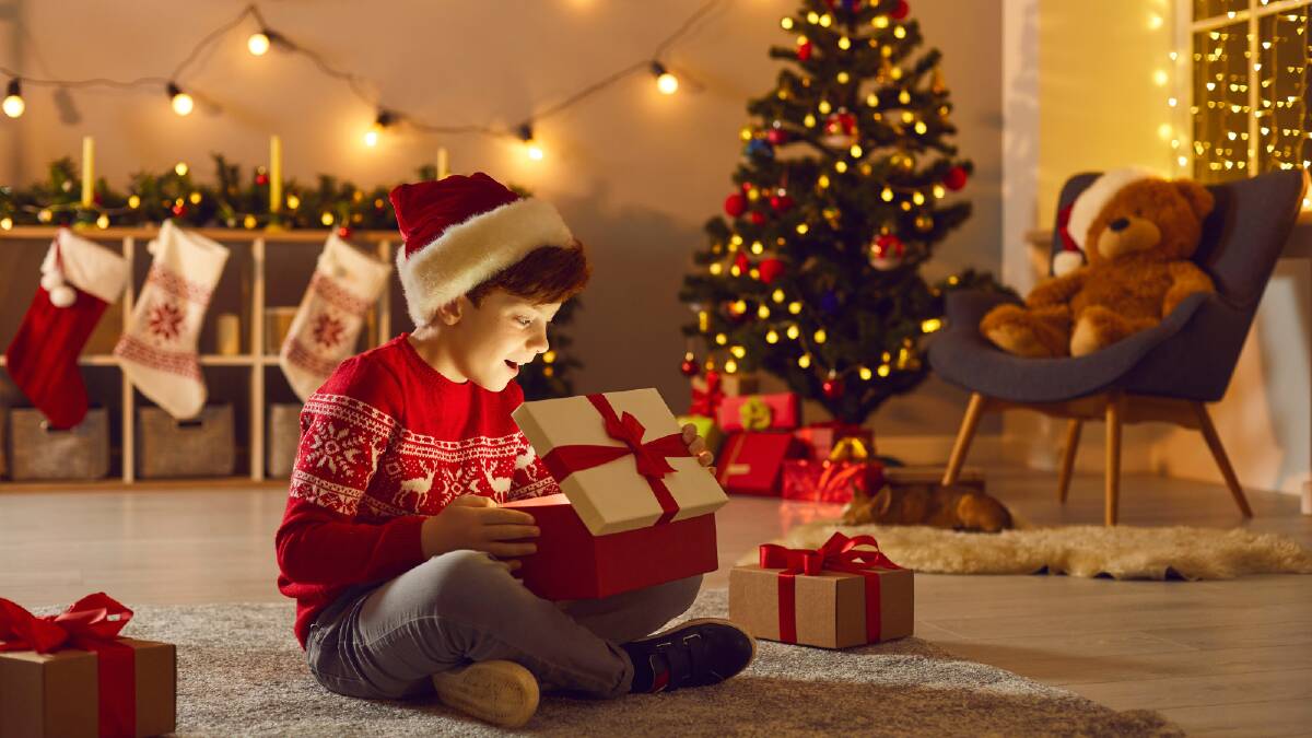 A child opening their Christmas present. Picture via Canva