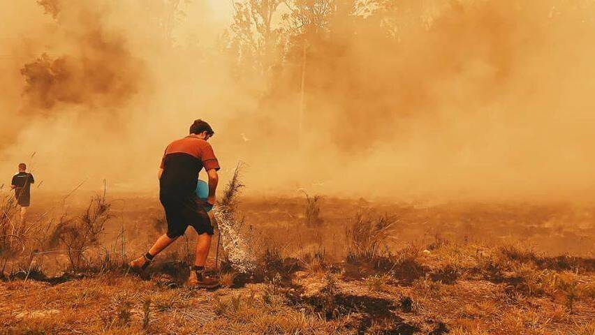 Firefighters and residents tried to make the most of the slight easing in conditions on Sunday. Photo: Talaya Abbott