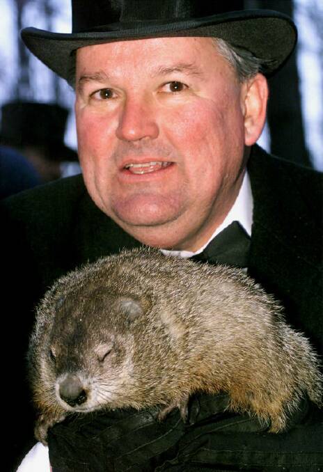 Punxsutawney Phil, the weather predicting groundhog, is held by handler Bill Deeley. 