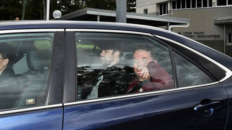 Suspended Logan City mayor Luke Smith (right) is seen being driven from the Logan Police Headquarters on Friday. Photo: AAP Image/Darren England

