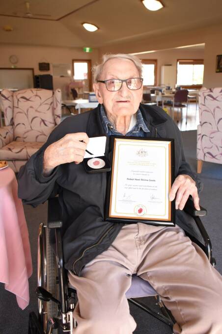 HUMBLY ACCEPTED ON BEHALF OF HIS MATES: Bob Smith with his World War II 75th anniversary commemorative medallion and certificate. 