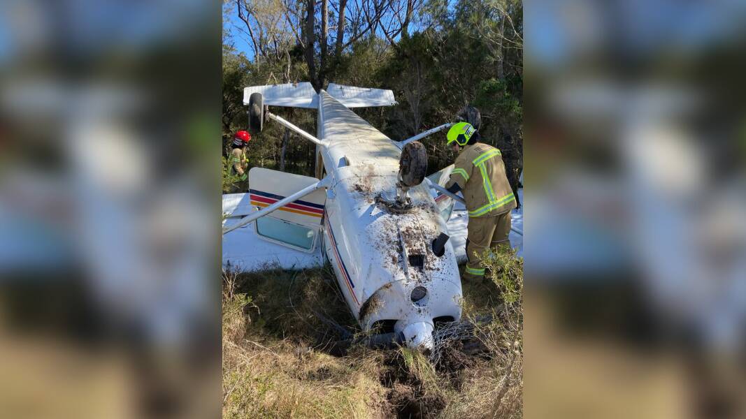 A small Cessna plane was pictured on its back in bushland after it crashed near Warnervale Airport on the NSW Central Coast on Monday morning. Photo: NSW Ambulance.