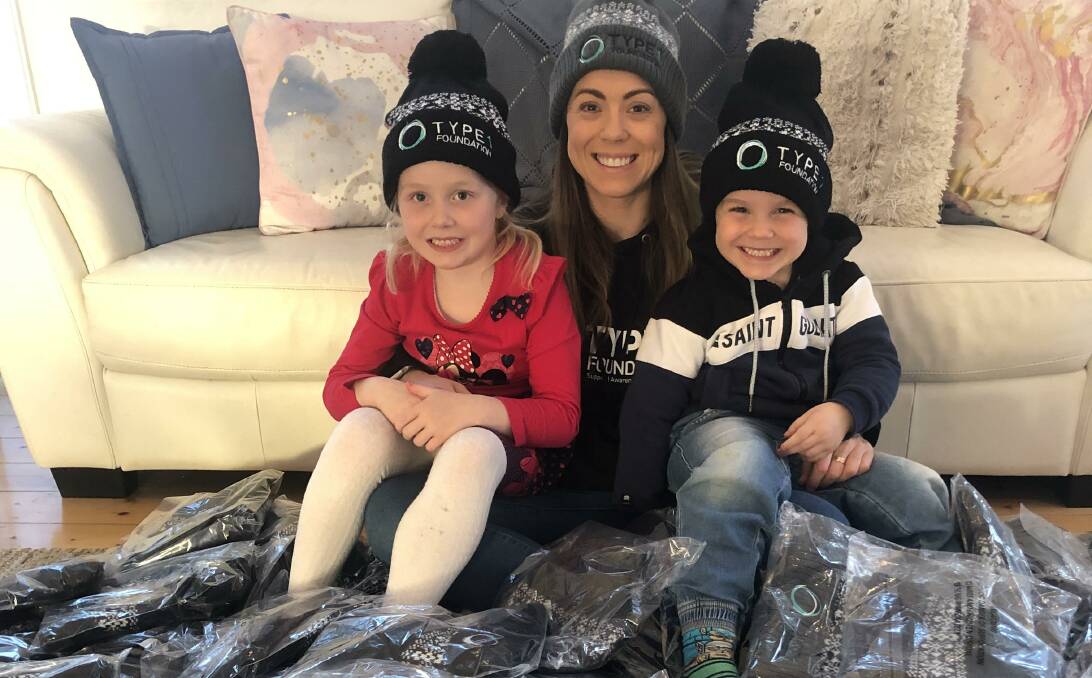 Naomi Glasson (centre) with Evie, 5, and Harry, 4, and the beanies they are selling to raise money for the Type 1 Foundation. Picture: supplied