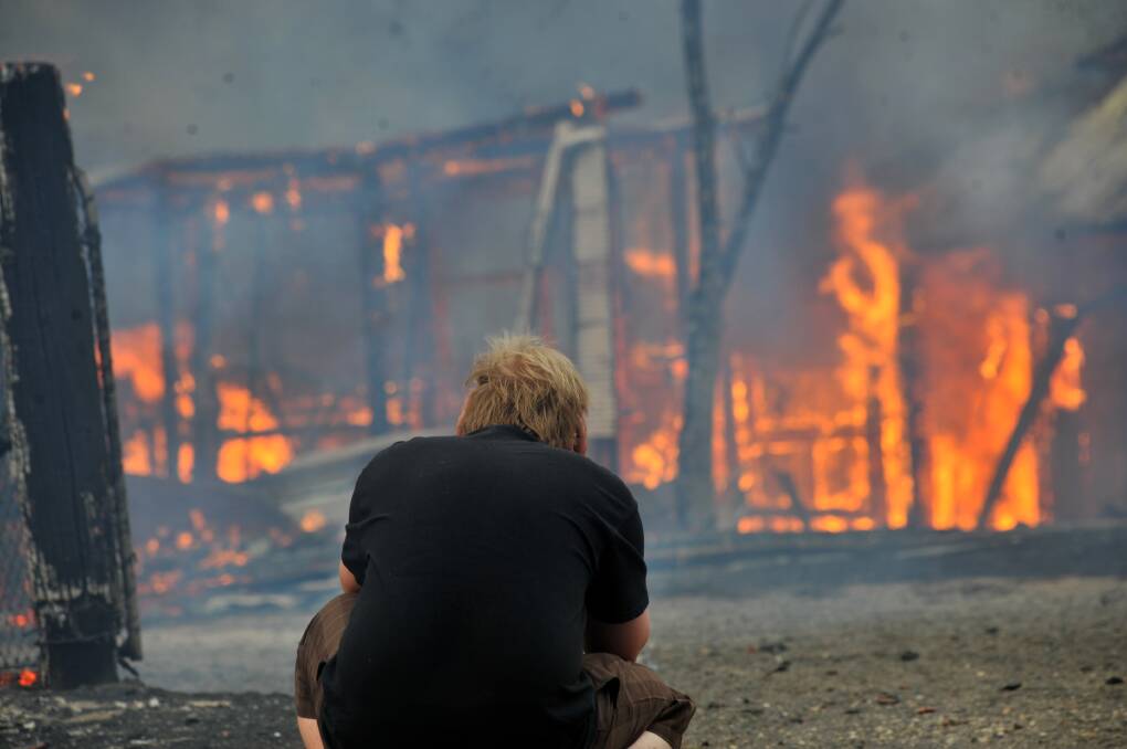 A resident watches another home be taken by fire as a Black Saturday fire reaches the city edge. Picture: PETER HYETT