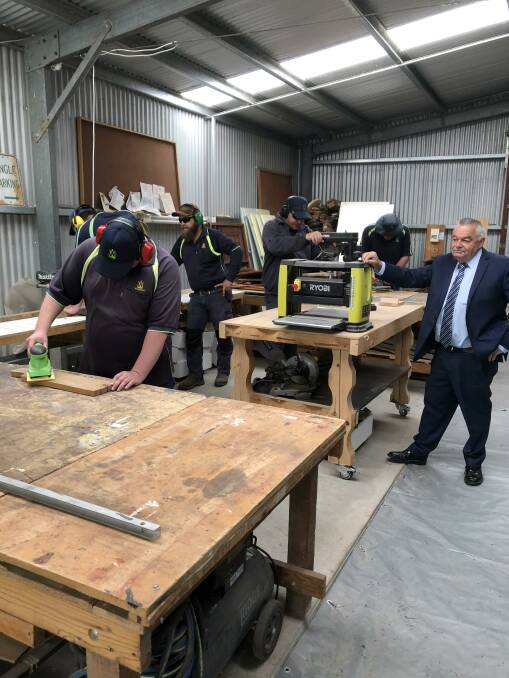 HARD TRUTHS: Woodbine chief executive Bernie O'Connor, right, with employees at the organisation's New Life Furniture facility. Picture: CONTRIBUTED