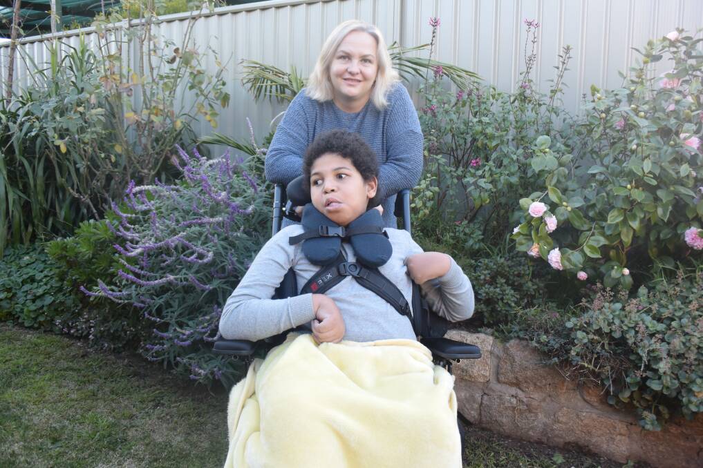 MOTHER AND SON: Kim and Ibitari Offoin enjoy some time together in their garden. Ibitari was born with lissencephaly, a rare, gene-linked brain malformation. Picture: ALICE RENNISON 