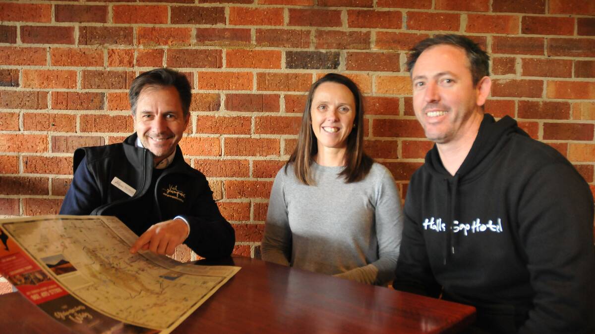 DISCOVERING HIGHLIGHTS: Grampians Tourism chief executive Marc Sleeman with Halls Gap Hotel owners Mary-Ann and Matt Humphries checking out the new Grampians Way Tourist map. Picture: CASSANDRA LANGLEY