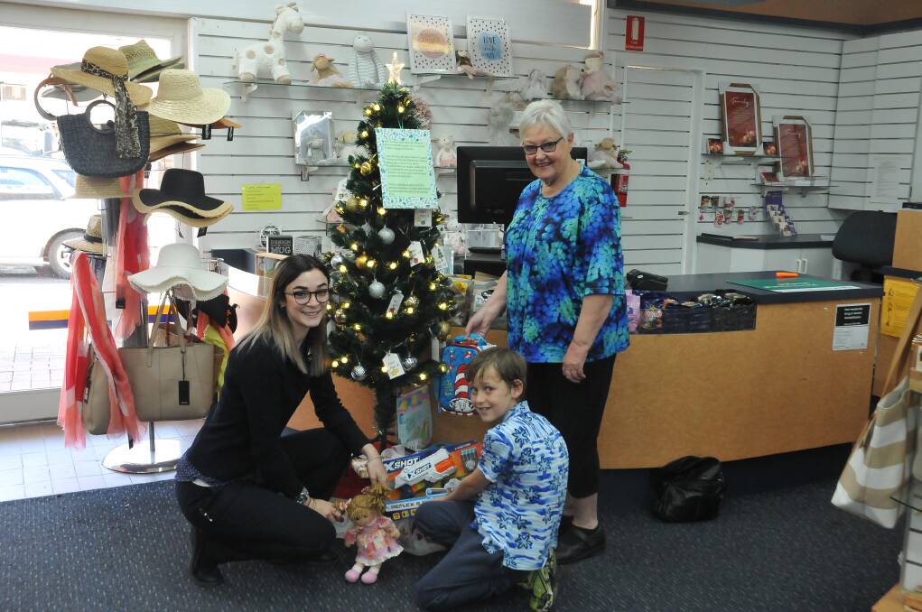 HELPING HANDS: Grampians Pharmacy's Chantelle Barber helps Zach put some presents under a Christmas Giving Tree with Jo Bertram. Picture: CASSANDRA LANGLEY