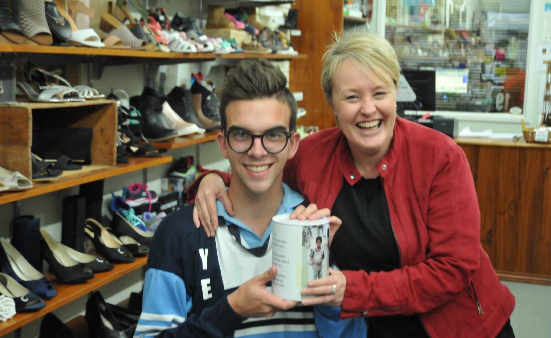 HELPING HAND: Marian College year 12 student Hugh Carey with Perry's Footware owner Janita Perry. Perry's Footware is one of the many stores where the fundraising tins are located. Picture: CASSANDRA LANGLEY