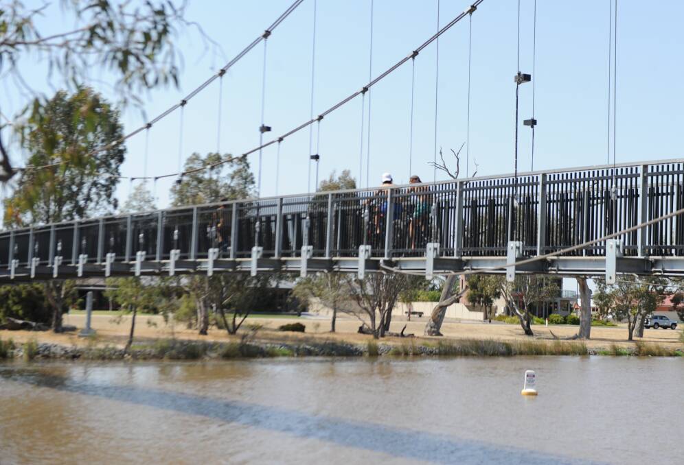 FEELING HOT: Teenage boys ride their bikes across the Anzac Centenary Bridge over the Wimmera River in Horsham on a hot day. Picture: ELIZA BERLAGE