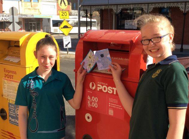 YOUNG ARTISTS: Lia from Concongella Primary School and Bridie from St Patrick’s Primary School with their postcard artworks. Picture: CONTRIBUTED