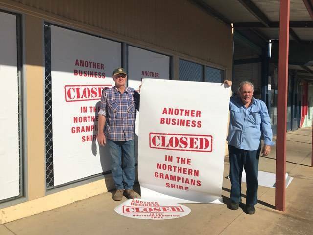 Stawell shearer Steven West assists Philip Scott place stickers protesting against the high number of business closures in the Northern Grampians Shire. 