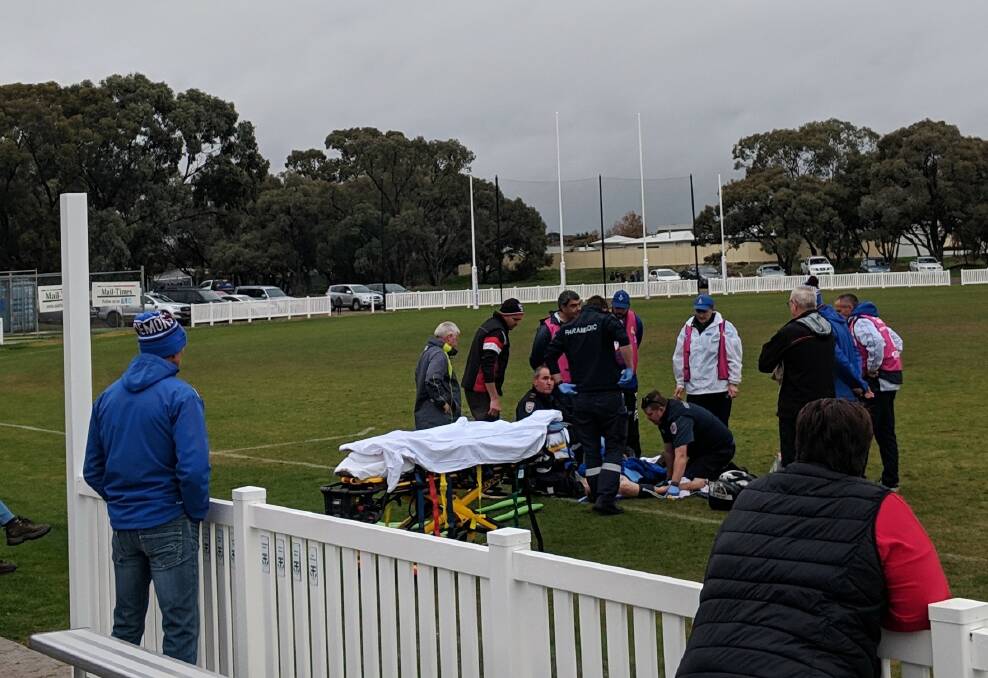 Trainers and paramedics prepare to stretcher Jordyn Burke off the field on Sunday. 