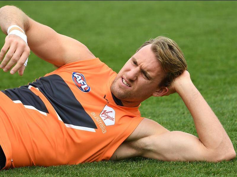 Lachlan Keeffe stretches during Giants training.