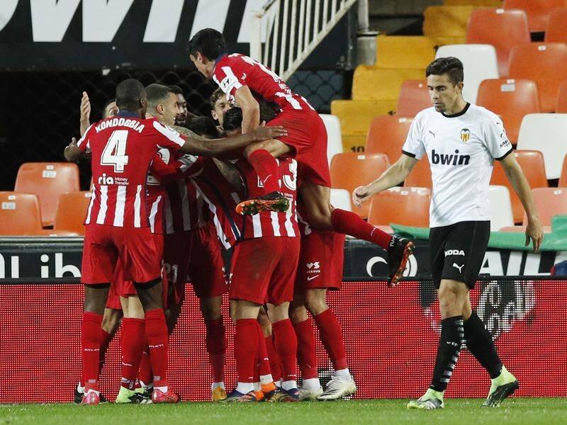 Atletico Madrid players celebrate the goal that earned them a huge win at Valencia's Mestalla.