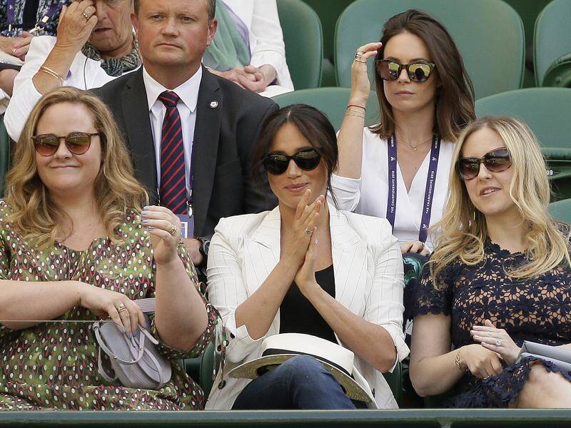 The Duchess of Sussex was flanked by two female companions as she took her seat at Wimbledon.