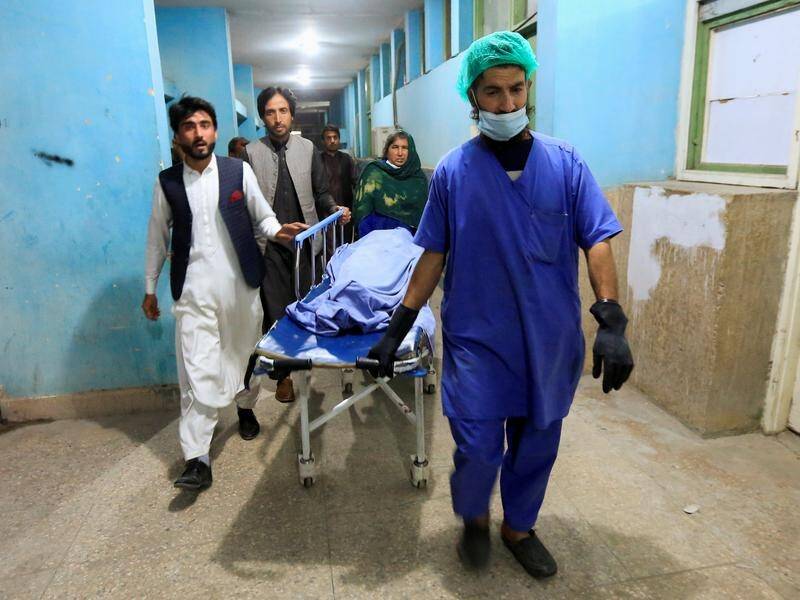 Hospital staff escort the body of one of three female media workers shot and killed in Afghanistan.