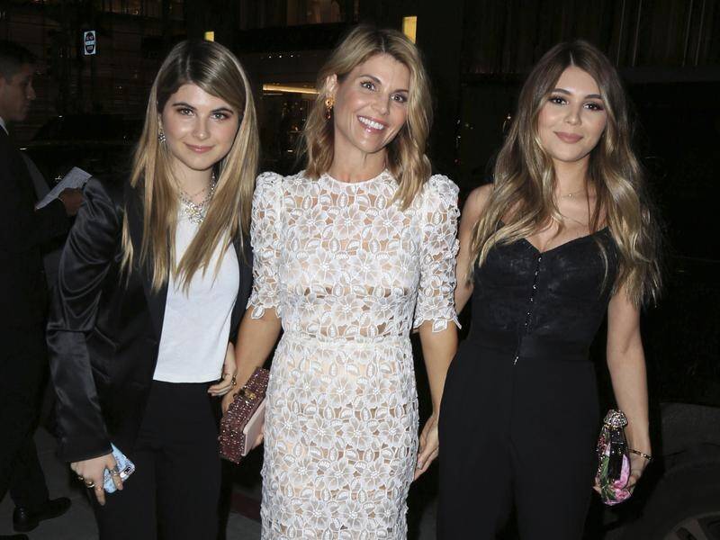 The daughters of actress Lori Loughlin (C) may be expelled by their uni over an admissions scam.