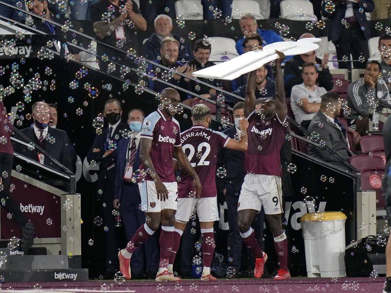 West Ham's Michail Antonio holds aloft a cardboard cutout of himself as he celebrates a goal.