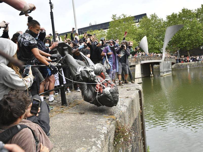 Protesters throw a statue of slave trader Edward Colston into Bristol harbour during a BLM rally.