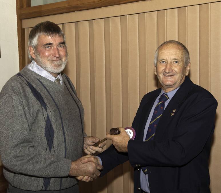 Newly elected president of the Stawell Lions Club, Ray Graham (left) accepts his president's badge and gavel from outgoing president Scott Fletcher. 