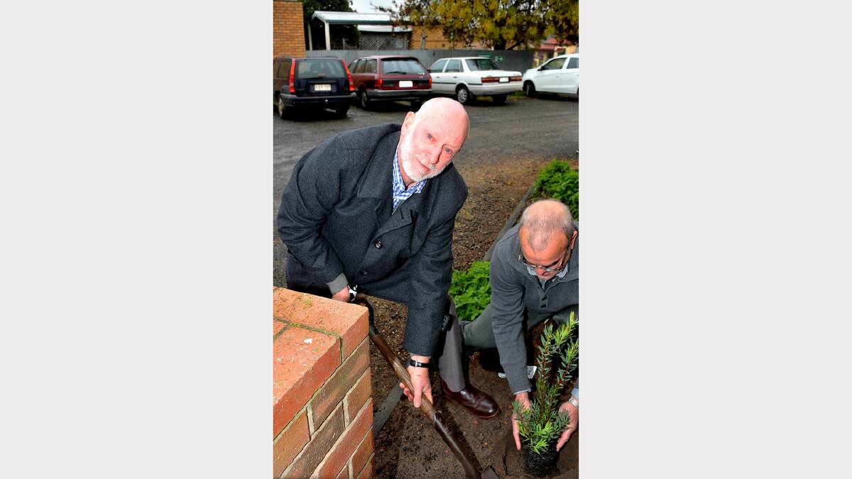 Allan Loats, who turned the first sod 20 years ago, assists Peter Evans with a tree planting.