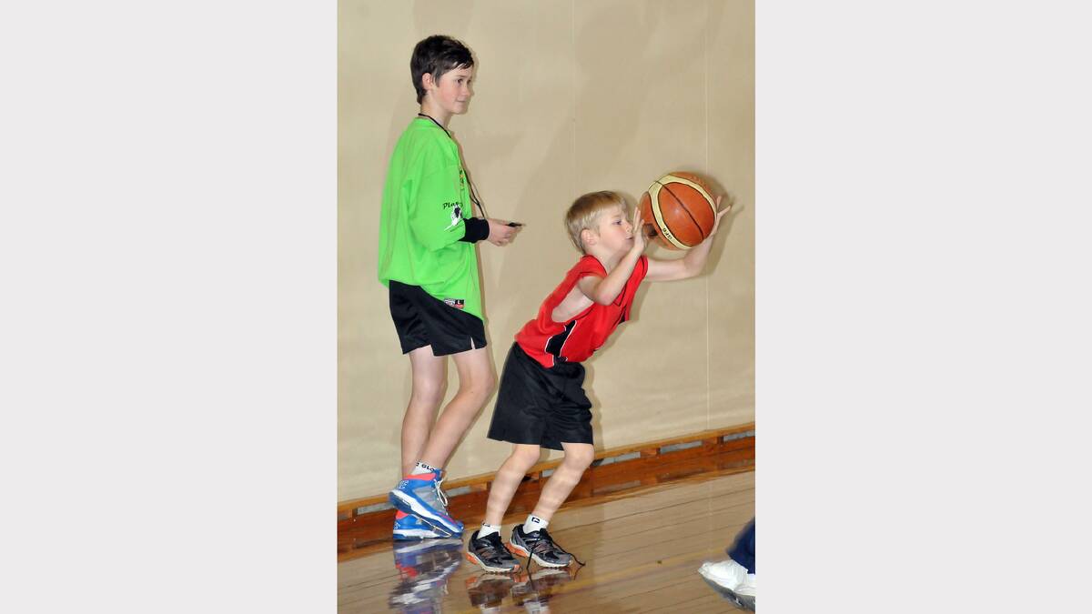 Youngster Heath brings the basketball back into play, watched closely by referee Declan Fry.