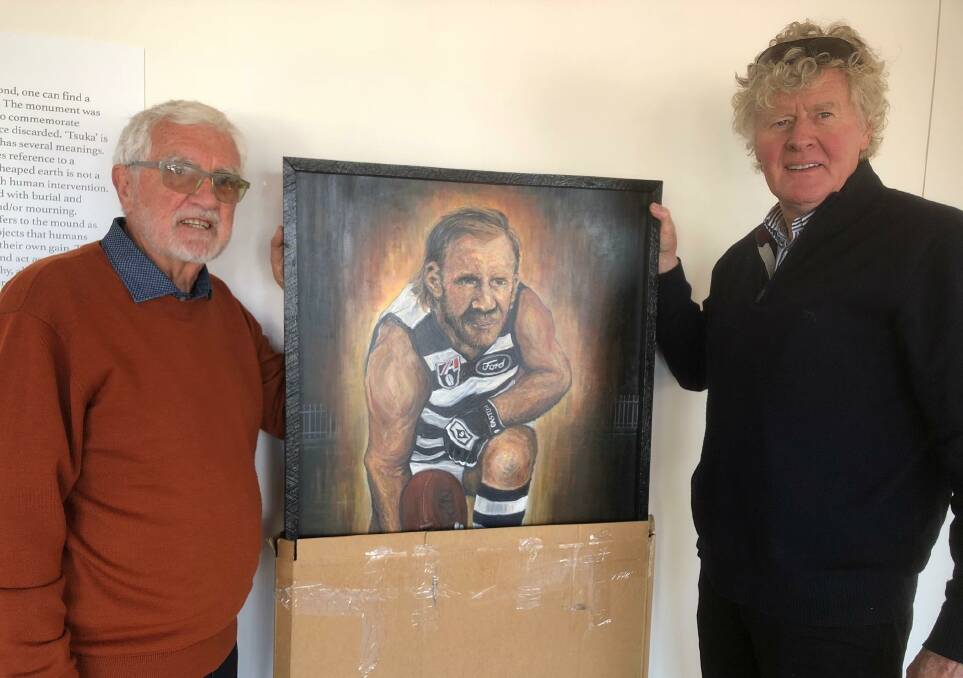 SETTING UP: Bob Utber and Chris Brain prepare artwork of Gary Ablett Snr for the exhibition at Willaura Railway Station Gallery. Picture: CONTRIBUTED