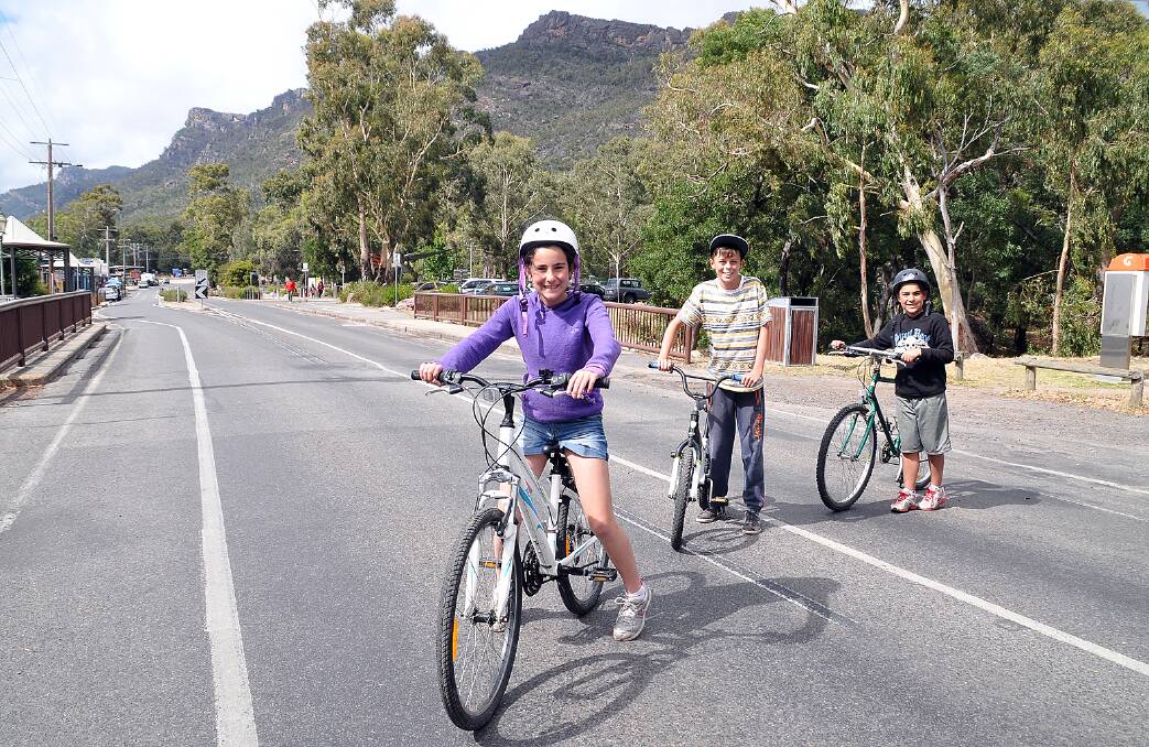 Young friends Zoe, George and Max make their way across Grampians Road in Halls Gap.