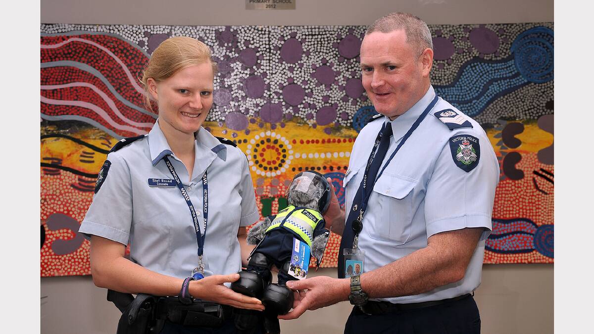 Constable Stef Round and Senior Sergeant Warren Groves with the new Constable T Bears in front of one of the murals completed by school students for the Stawell Police Station.