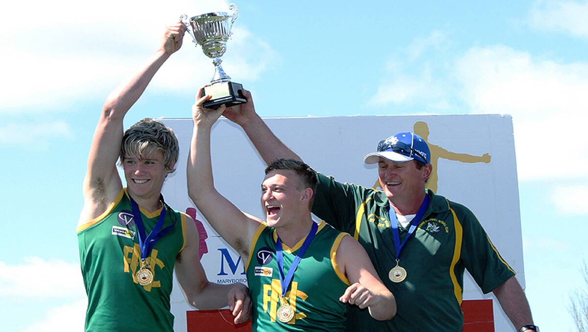 L-R Jayden Fowkes, Jesse Hannett and coach Tim Bibby with the premiership cup after Navarre took out the under 17.5s football grand final on Sunday. Picture: ROWDY DAWSON