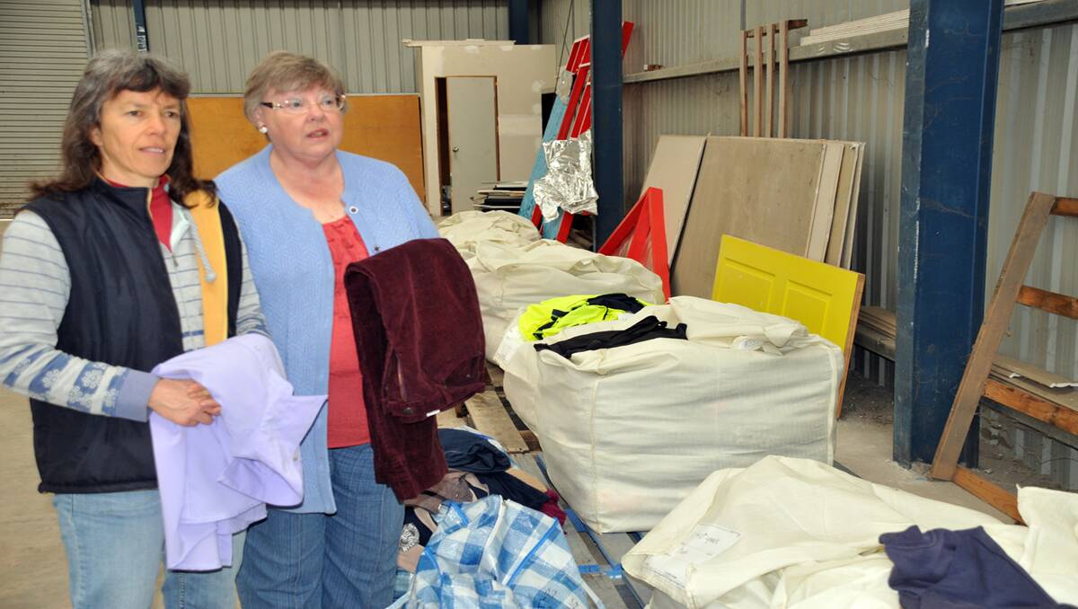Coordinator of the Clothes for Vanuatu project, Debbie Evans, prepares to sort through wool bales filled with donated clothing, together with volunteer Marie Mackie, at the Mitre 10 shed in Gilchrist Road.